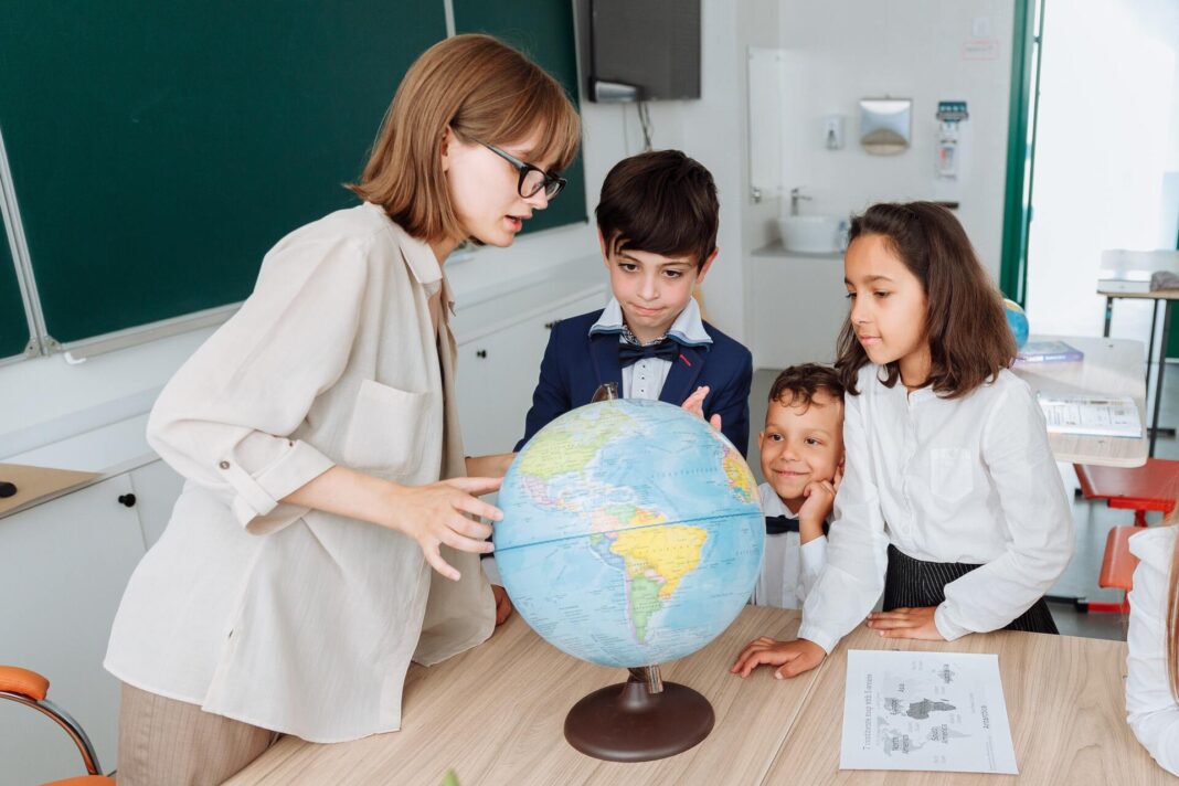 Učitelka, globus, žáci, platy učitelů a dalších pedagogů 2022
