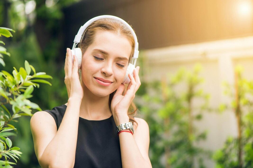 žena poslouchá hudbu přes sluchátka, stahování písniček (MP3) a videí (MP4) z YouTube online